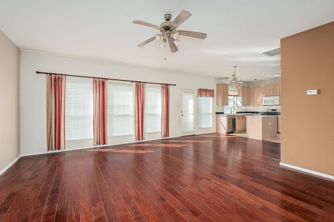 Unfurnished living room featuring wood finished floors and a ceiling fan | Image 12