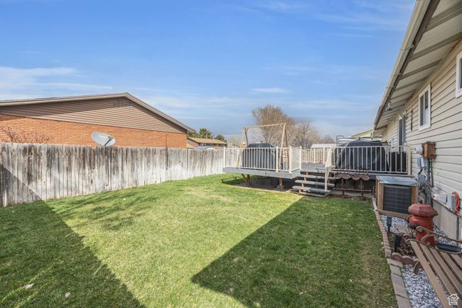 View of yard featuring cooling unit, fence private yard, and a wooden deck | Image 23