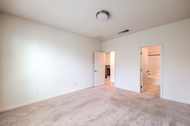 Unfurnished bedroom featuring light carpet, ensuite bath, baseboards, and visible vents | Image 22