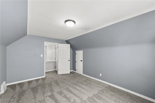 Primary bedroom with carpet and access to eaves for storage | Image 24