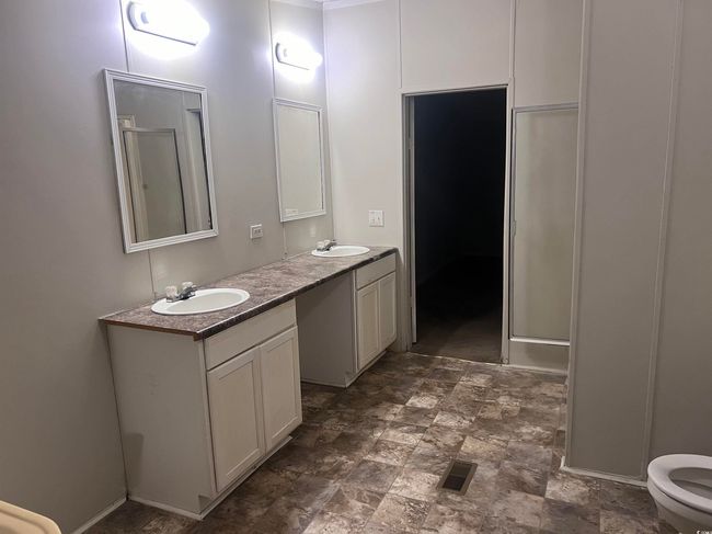 Bathroom with double vanity, stone finish floors, and a shower with shower door | Image 13