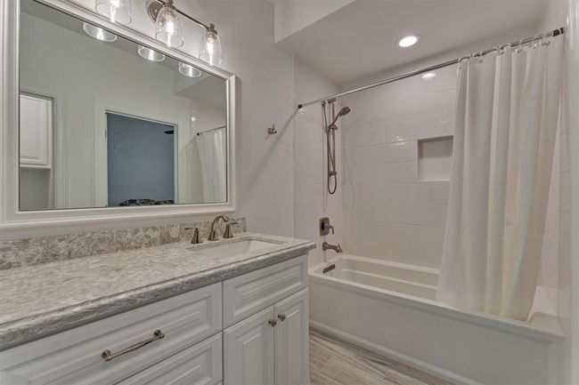A full bath on the first floor features an oversized soaking tub by Kohler, (32x66x19), elegant quartz countertops, and stylish lighting. | Image 30