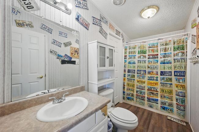 Full bath with vanity, a textured ceiling, wood finished floors, and curtained shower | Image 16