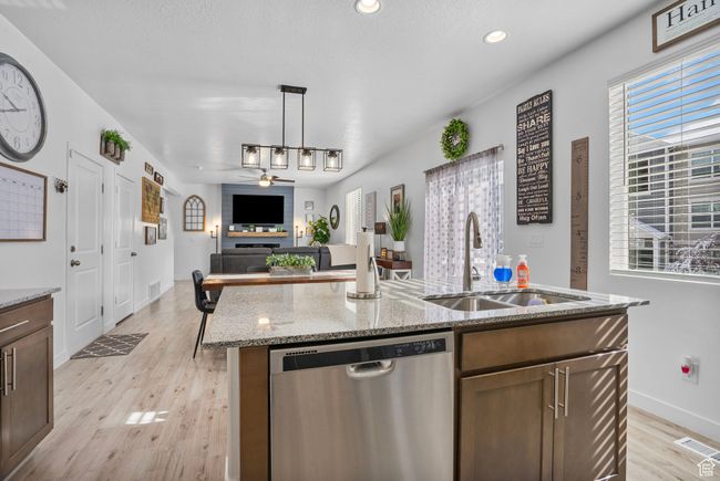 Kitchen with a sink, visible vents, light wood-style floors, ceiling fan, and dishwasher | Image 6