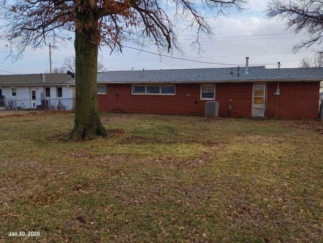 Rear view of house with central AC unit and a yard | Image 10