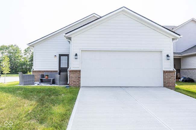 ranch-style house with brick siding, concrete driveway, a garage, and a front yard | Image 20