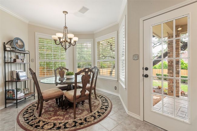 Sunny breakfast nook with bay windows opens to the kitchen and living, offering a perfect spot for daily dining and backyard views. | Image 17