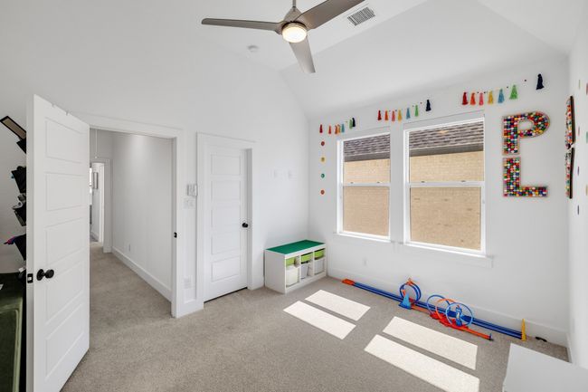 Playroom with ceiling fan, vaulted ceiling, light colored carpet, and baseboards | Image 28