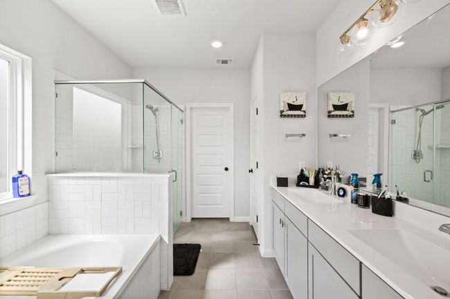 Bathroom with a shower stall, visible vents, tile patterned flooring, and a sink | Image 14