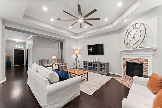 Step into the spacious living room with added led lights, upgraded ceiling fan and brick front fireplace. | Image 5
