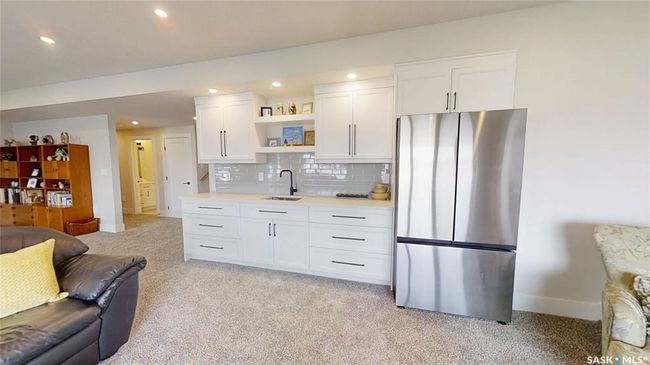 Kitchen with freestanding refrigerator, light carpet, open shelves, light countertops, and open floor plan | Image 26