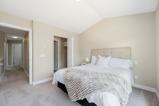 Bedroom with lofted ceiling, light colored carpet, and baseboards | Image 10
