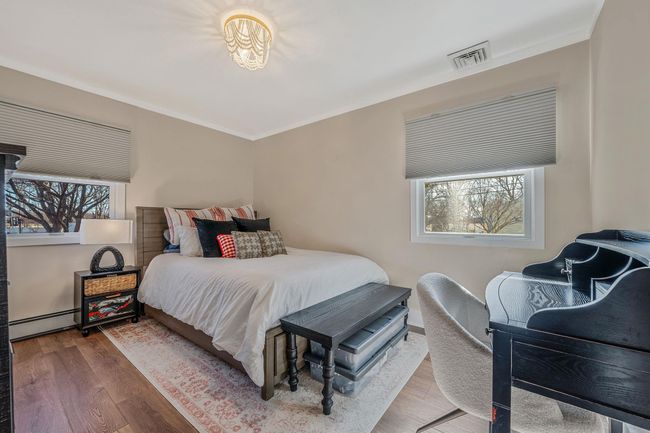 Bedroom featuring wood-type flooring, ornamental molding, and baseboard heating | Image 12
