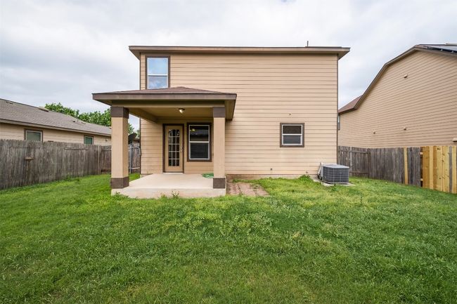 Rear view of house featuring a fenced backyard, central AC unit, a patio, and a lawn | Image 36