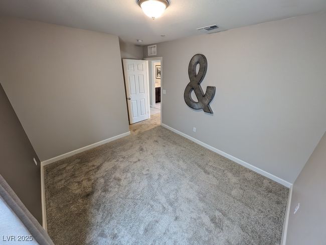 Unfurnished bedroom with light carpet and baseboards | Image 33