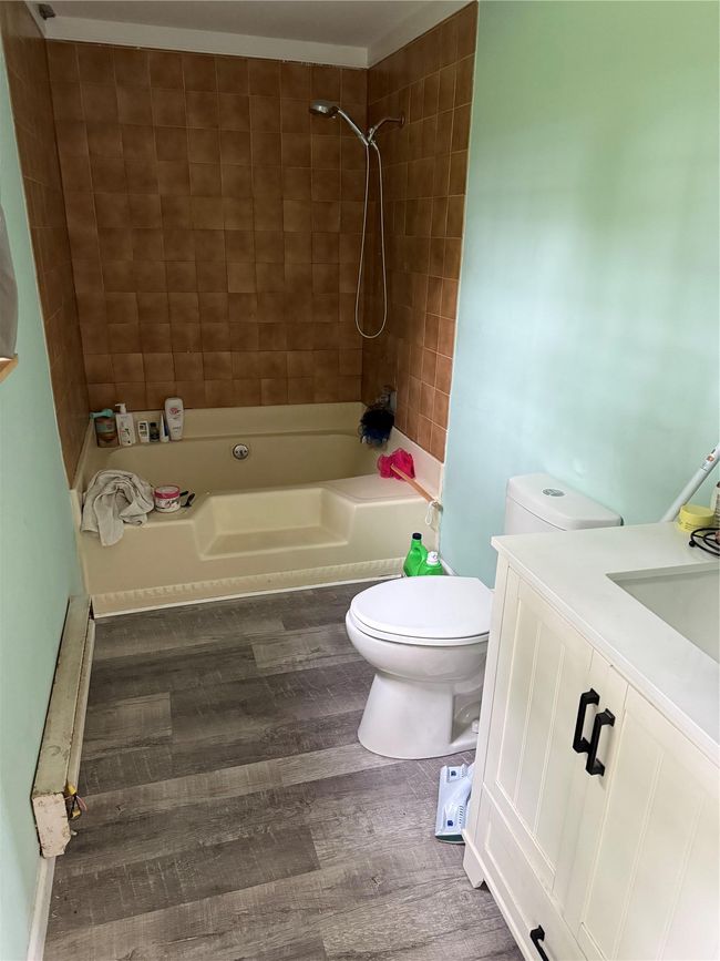 Bathroom featuring toilet, shower / tub combination, wood finished floors, and vanity | Image 9