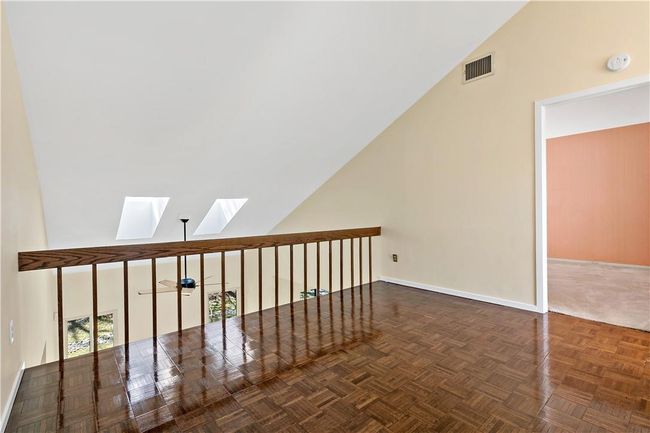 Balcony with parquet floors open to the living room below. | Image 16