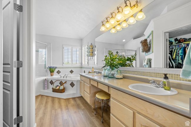 Full bath with double vanity, a shower stall, a sink, and wood finished floors | Image 37