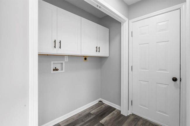Laundry room with cabinet space, dark wood-style flooring, electric dryer hookup, hookup for a washing machine, and baseboards | Image 13