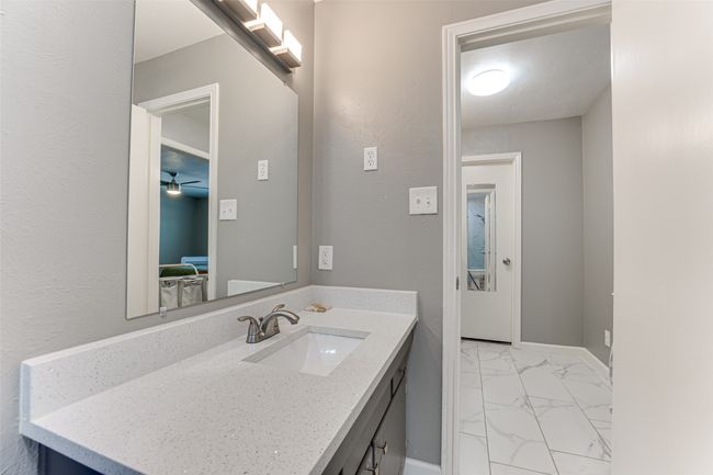 Bathroom featuring baseboards, a ceiling fan, marble finish floor, and vanity | Image 17