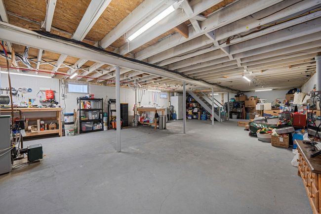 Basement featuring white refrigerator and a workshop area | Image 20