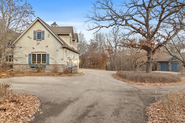 Approach from driveway with three garage stalls in the attached garage and three more stalls in the detached garage. | Image 74
