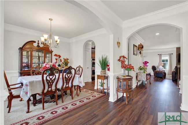 Foyer view into the dining room and family room with beautiful details of arched doorways and custom trim work and moldings | Image 5