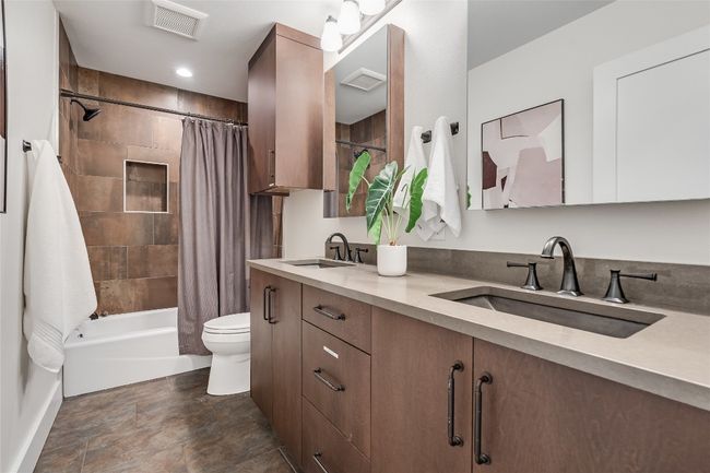 The full secondary bathroom also comes beautifully updated with a dual vanity and provides an updated shower/tub combo with designer tile backsplash. | Image 31