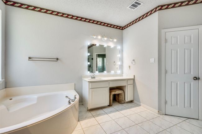 Master Bath with her sink & vanity, a tub & toilet | Image 15