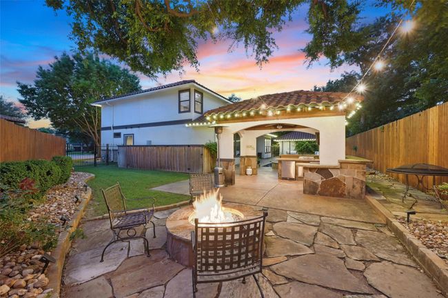 Back of property featuring a fire pit, a tiled roof, stucco siding, and a patio | Image 39