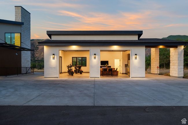 Rear view of property featuring driveway, an attached garage, and stucco siding | Image 71