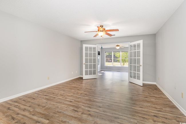 Unfurnished room with wood finished floors, baseboards, ceiling fan, and french doors | Image 18