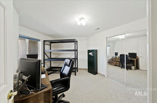 Carpeted office space featuring a textured ceiling and baseboards | Image 28
