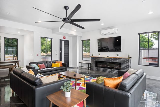 Living room featuring a brick fireplace, a healthy amount of sunlight, an AC wall unit, and ceiling fan | Image 10
