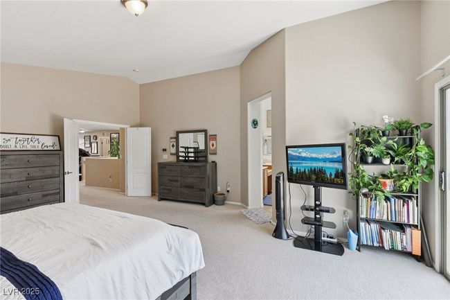 Bedroom with vaulted ceiling, carpet, baseboards, and connected bathroom | Image 47
