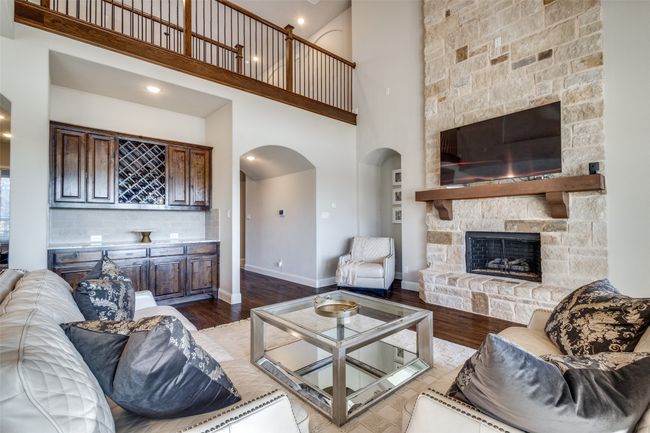 Living room with bar, a towering ceiling, hardwood / wood-style floors, and a fireplace | Image 8