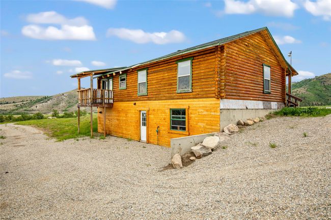 View of property exterior featuring log siding and a deck with mountain view | Image 28