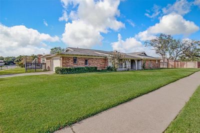 Ranch-style home featuring a garage and a front lawn | Image 2