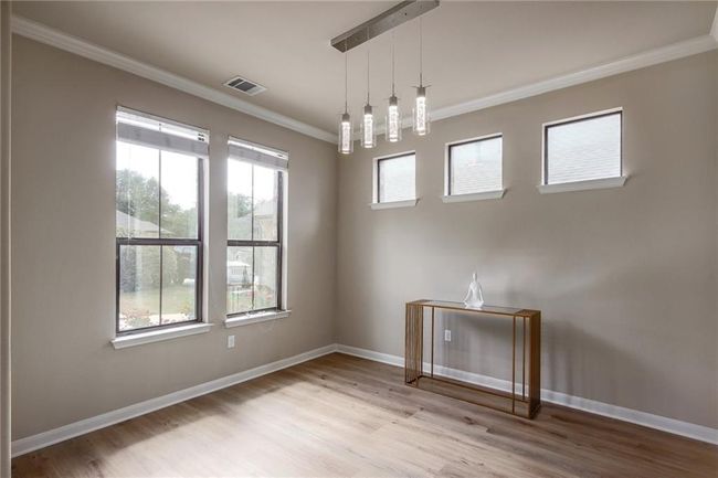 Spare room featuring ornamental molding and wood finished floors | Image 13