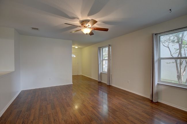 Unfurnished room with ceiling fan, dark wood finished floors, and baseboards | Image 17