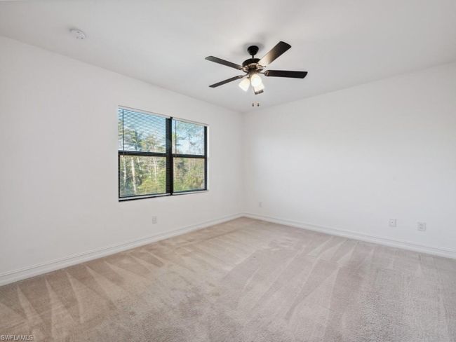 Carpeted empty room featuring ceiling fan | Image 16