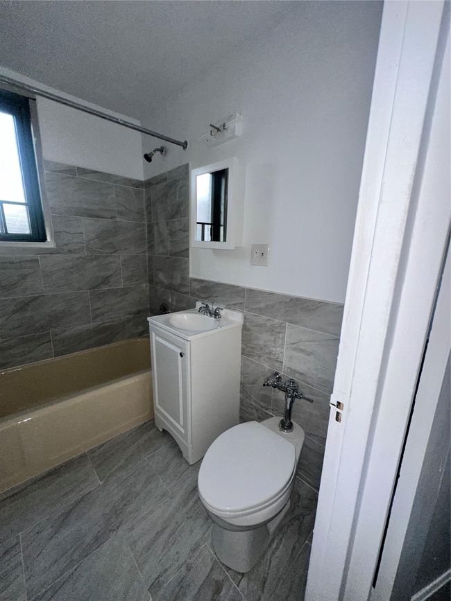 Bathroom featuring toilet, a textured ceiling, vanity, tile walls, and shower / bathtub combination | Image 16