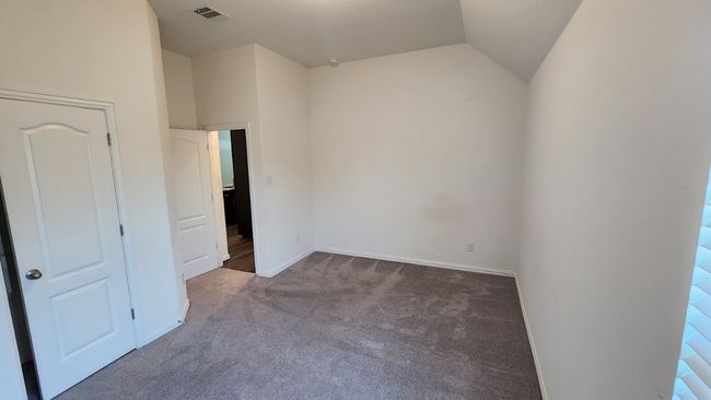 Unfurnished bedroom with carpet, vaulted ceiling, and baseboards | Image 28
