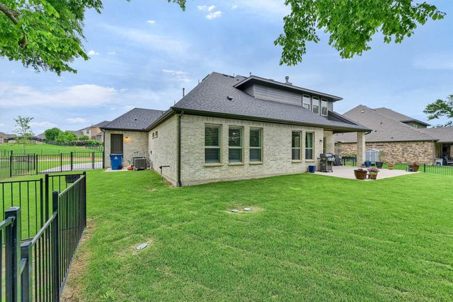 Rear view of property featuring a yard, cooling unit, a patio area, and roof with shingles | Image 34