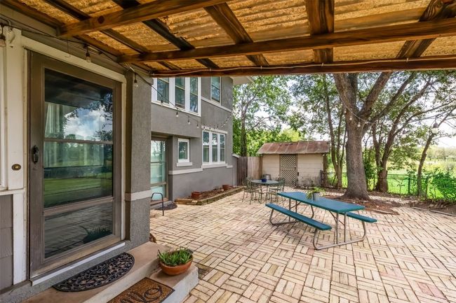 View of patio featuring outdoor dining area and a storage shed | Image 33