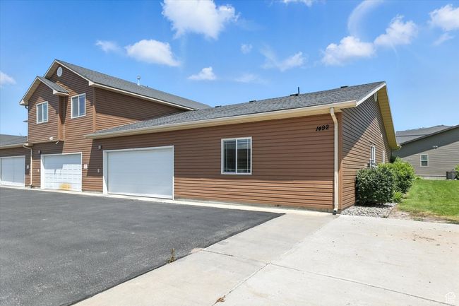 View of property exterior featuring asphalt driveway, a garage, and a shingled roof | Image 27