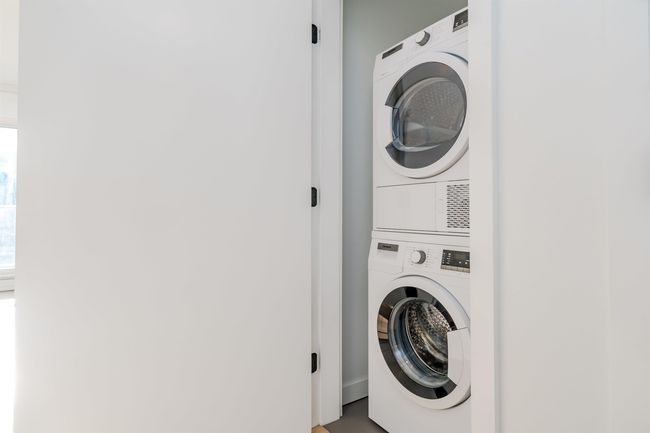 Washroom with stacked washing maching and dryer | Image 27