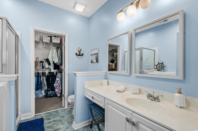 Full bath featuring a stall shower, a walk in closet, and vanity | Image 24