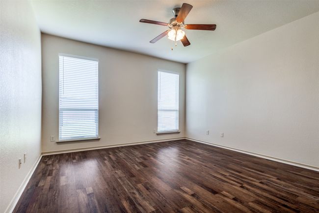 Spare room with dark wood-type flooring and a ceiling fan | Image 19
