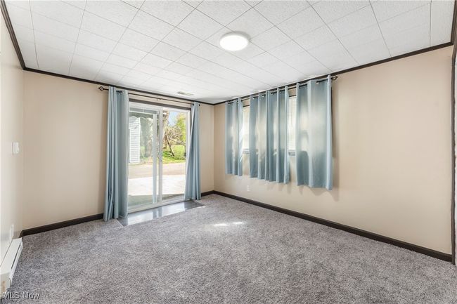 Unfurnished room with a baseboard radiator, crown molding, carpet flooring, and baseboards | Image 21